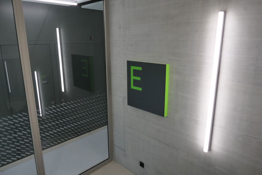 Gebäudebeschriftungs-Schild montiert an Betonwand, Innenanwendung