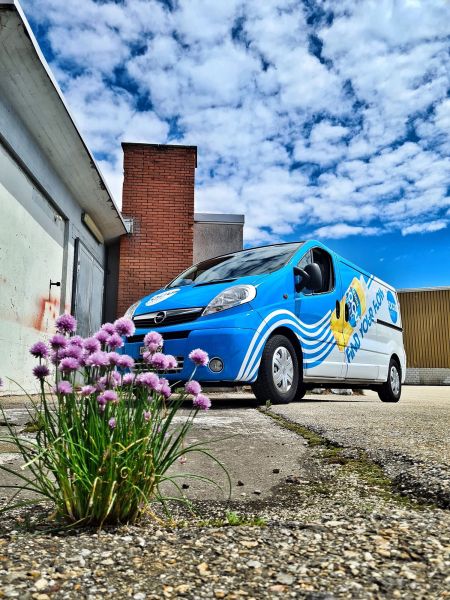 Opel Transporter mit blauer, Wellen förmiger Beschriftung.