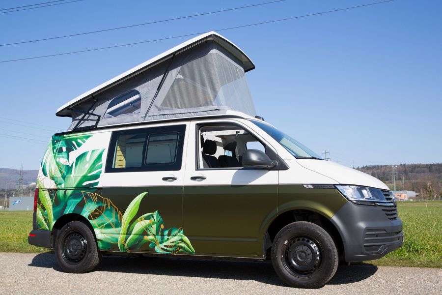 Camping Bus mit ausgeklapptem Dach mit Teilfolierung in Grün Metalisé und grünem Blatt Motiv.