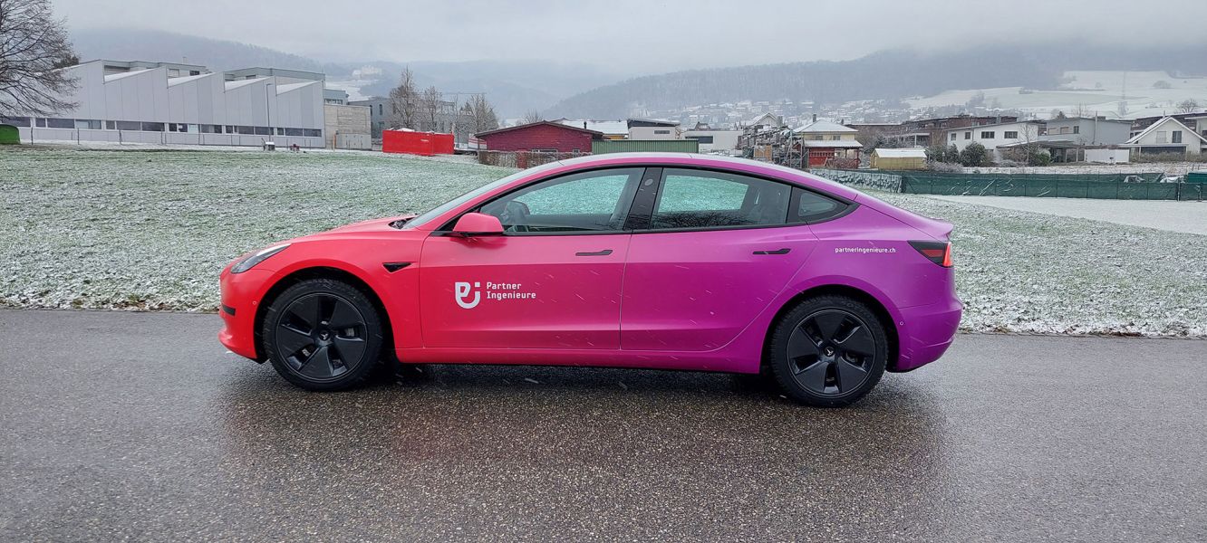 Vollfollierter Tesla in Pinkverlauf-Tönen mit Aufschrift Partner Ingenieure