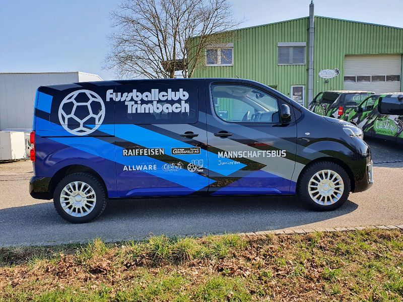 Junioren Mannschaftsbus mit blauen Streifen, mit Logobeschriftungen.