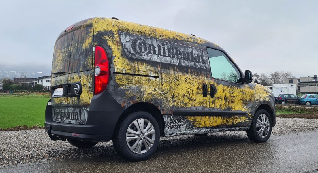 Kleiner Transportbus mit Vollfolierung in Gelb, Schwarz und Weiss im Aquarell Look.